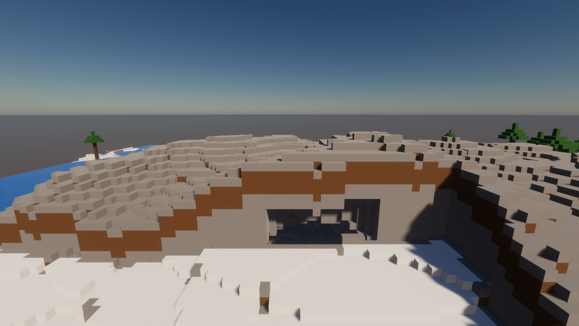 Snow-capped voxel mountain peaks under clear daylight